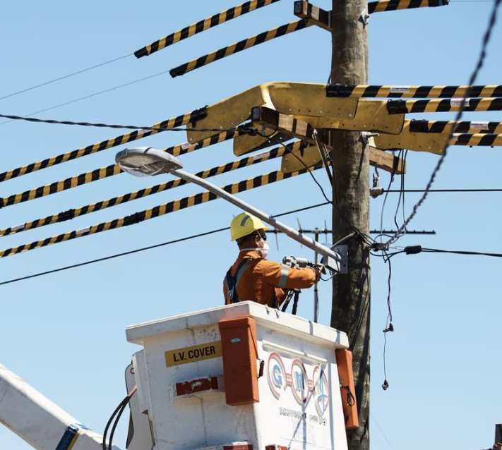 Level 2 electrician working on overhead power lines from an elevated bucket